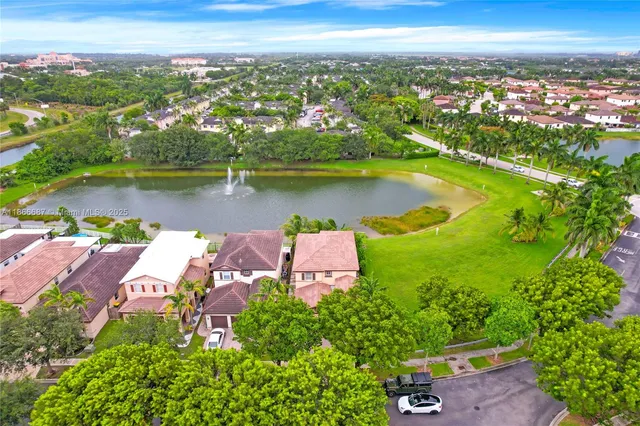 an aerial view of a city with lots of residential buildings ocean and mountain view in back