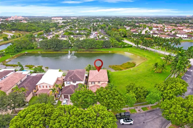 an aerial view of residential houses with outdoor space and lake view