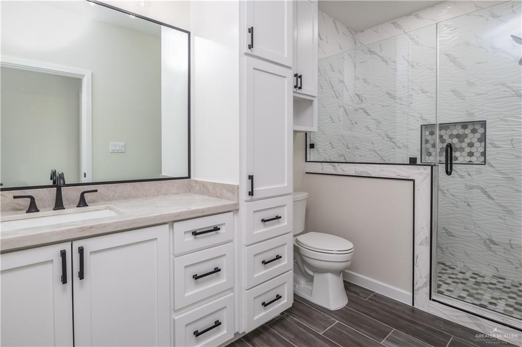 3559 Satelite Street Edinburg, TX 78542 - Photo 13 of 22 a bathroom with a granite countertop toilet a sink and a mirror