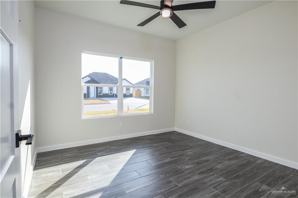 3559 Satelite Street Edinburg, TX 78542 - Photo 14 of 22 an empty room with wooden floor fan and windows