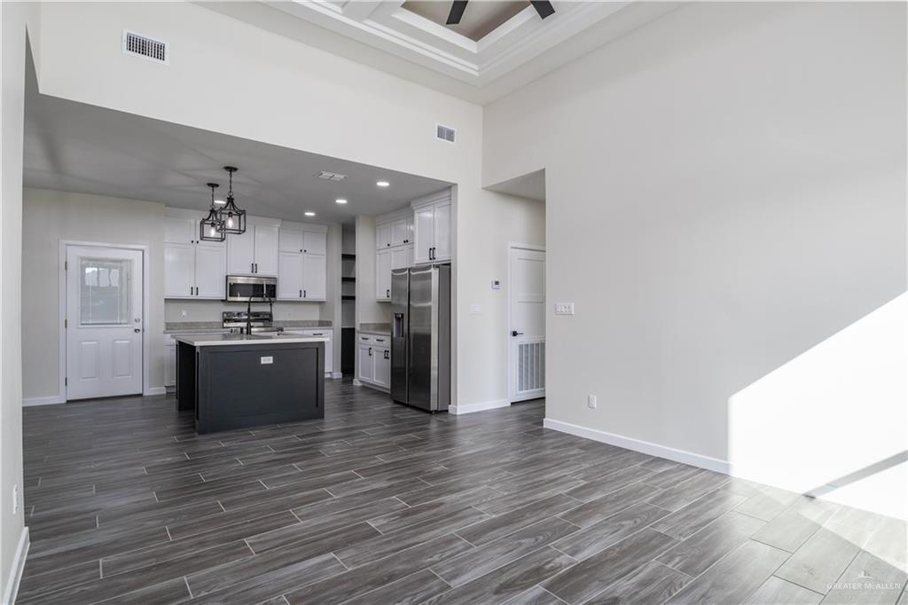 3559 Satelite Street Edinburg, TX 78542 - Photo 2 of 22 a large kitchen with a wooden floor and stainless steel appliances