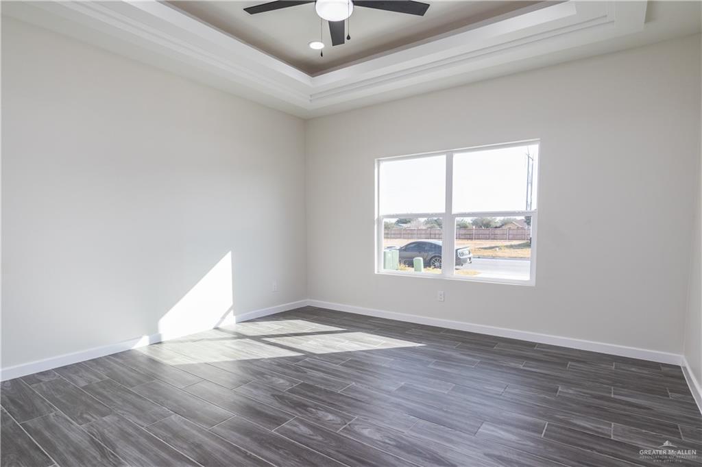 3559 Satelite Street Edinburg, TX 78542 - Photo 8 of 22 an empty room with wooden floor and windows