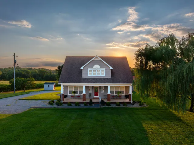 a view of a house with a big yard and large trees