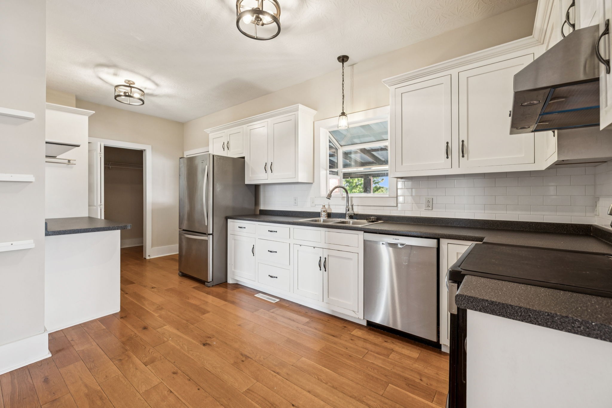572 Buntin Mill Road Cottontown, TN 37048 - Photo 28 of 67 a kitchen with stainless steel appliances granite countertop a refrigerator a sink dishwasher a stove and white cabinets with wooden floor