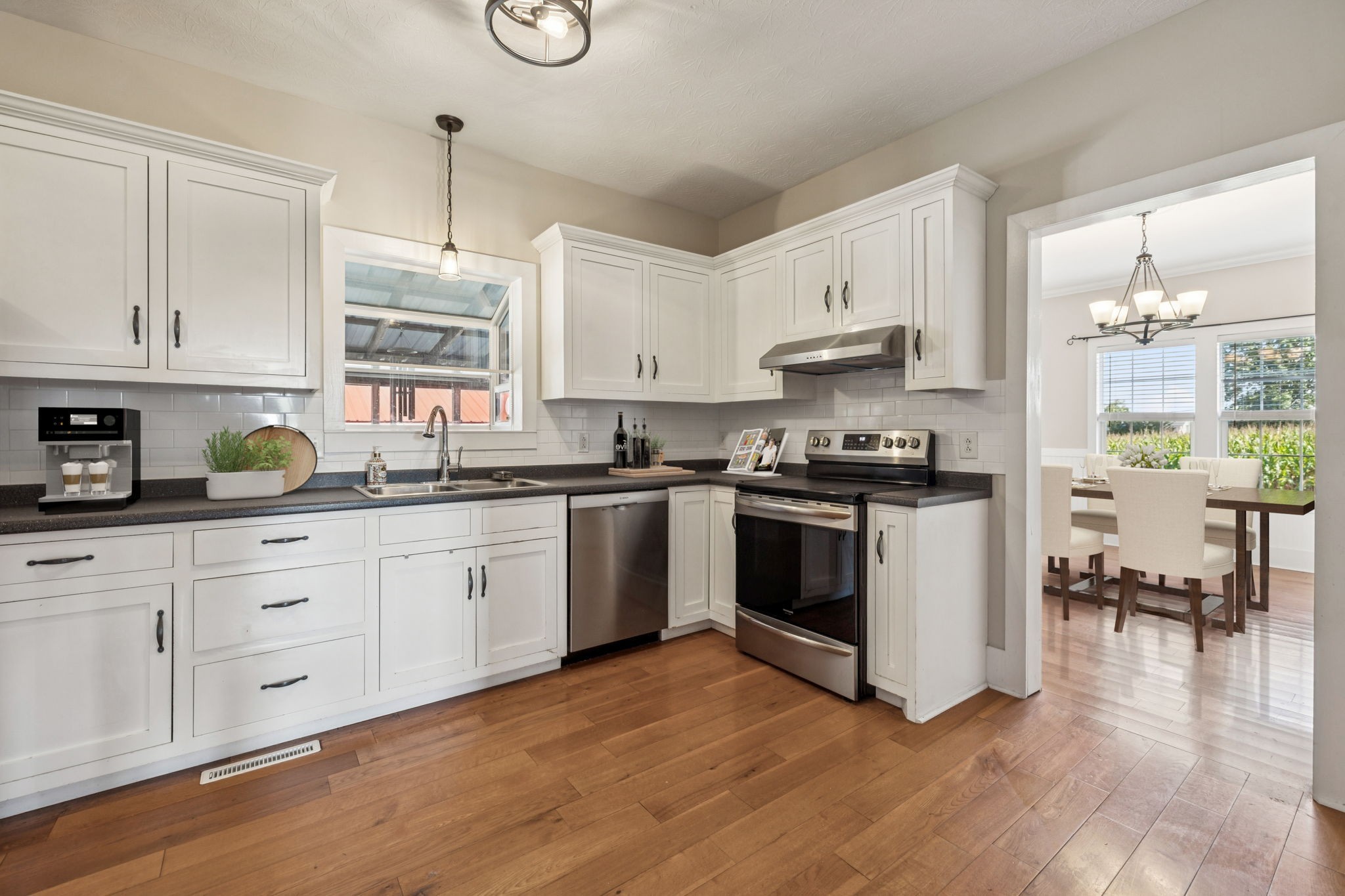 572 Buntin Mill Road Cottontown, TN 37048 - Photo 31 of 67 a kitchen with granite countertop a stove a sink and white cabinets with wooden floor
