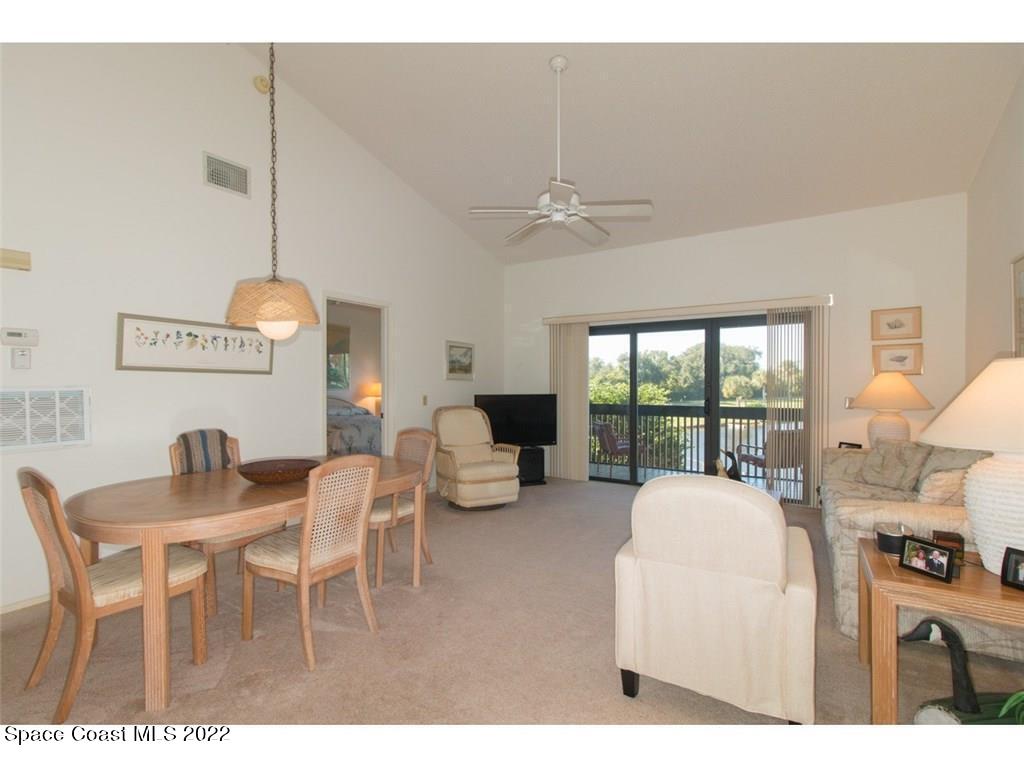 9640 Estuary Way, Unit 3 Sebastian, FL 32958 - Photo 10 of 24 a living room with furniture a chandelier and a large window