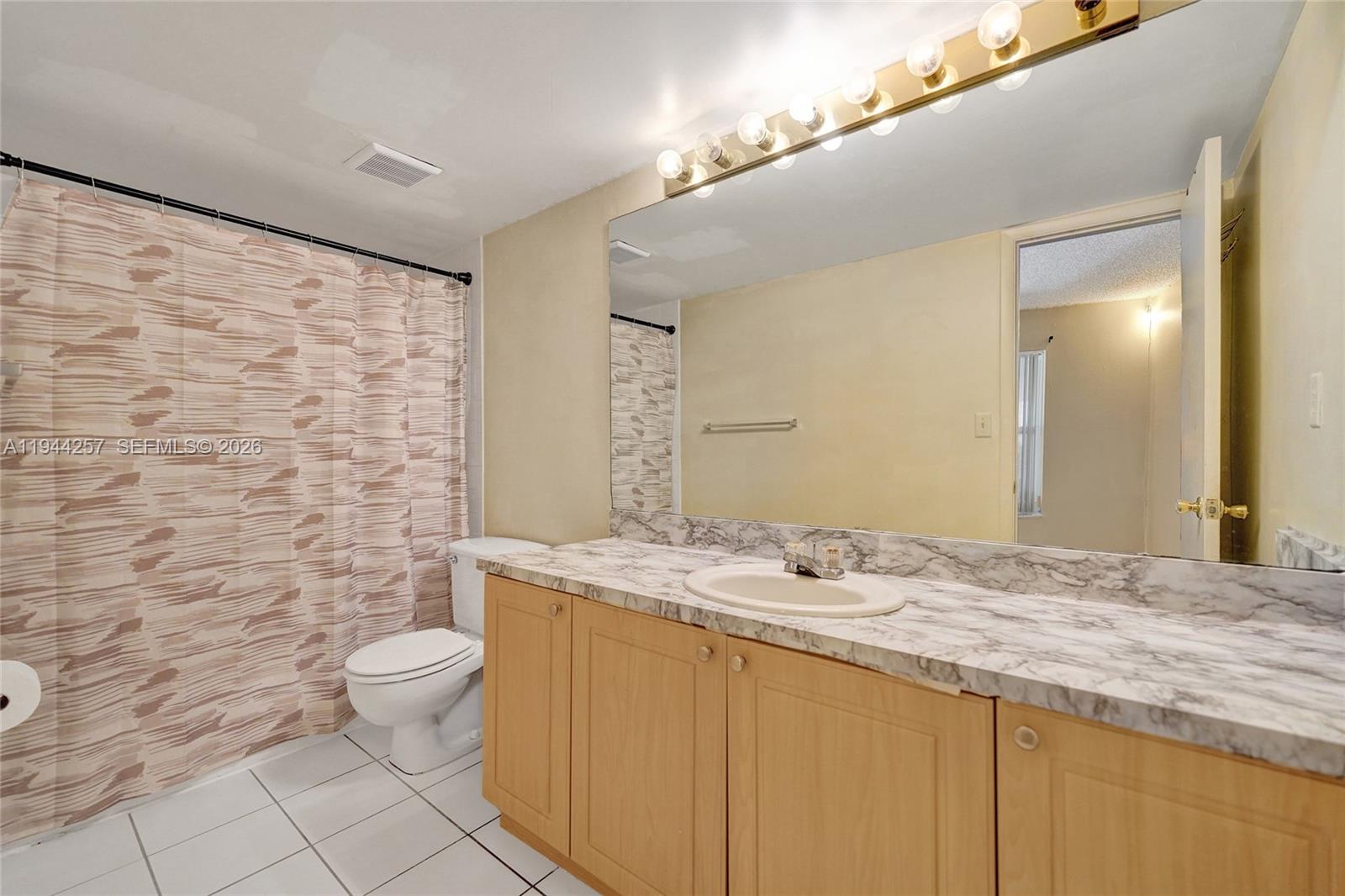505 South Pine Island Road, Unit 405B Plantation, FL 33324 - Photo 19 of 43 a bathroom with a granite countertop sink a toilet and a mirror