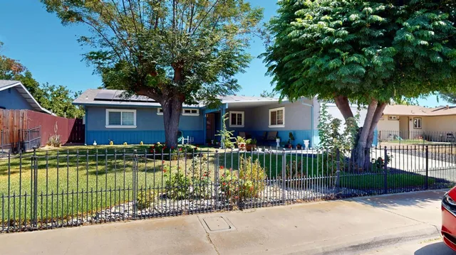 a front view of a house with a garden and yard