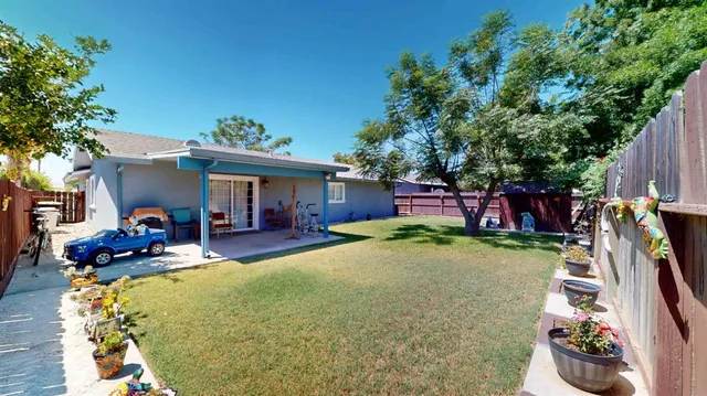 a view of a house with backyard and sitting area