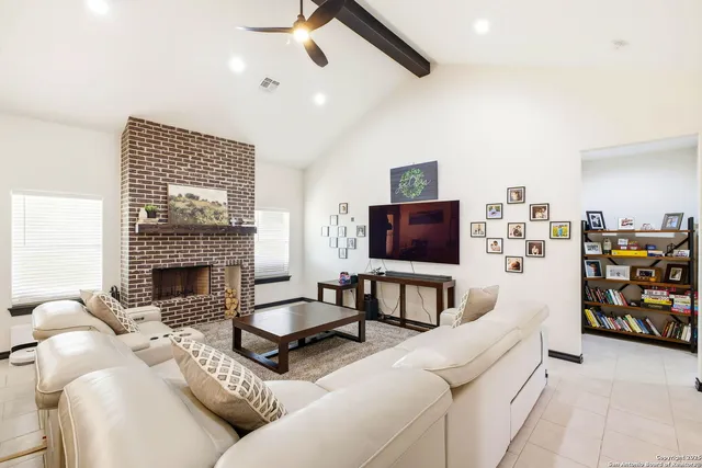 a living room with furniture a flat screen tv and a fireplace