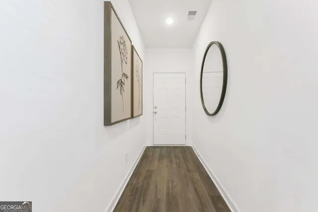 a picture of a room with wooden floor and white walls