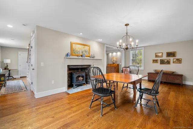 a dining room with furniture a chandelier and wooden floor