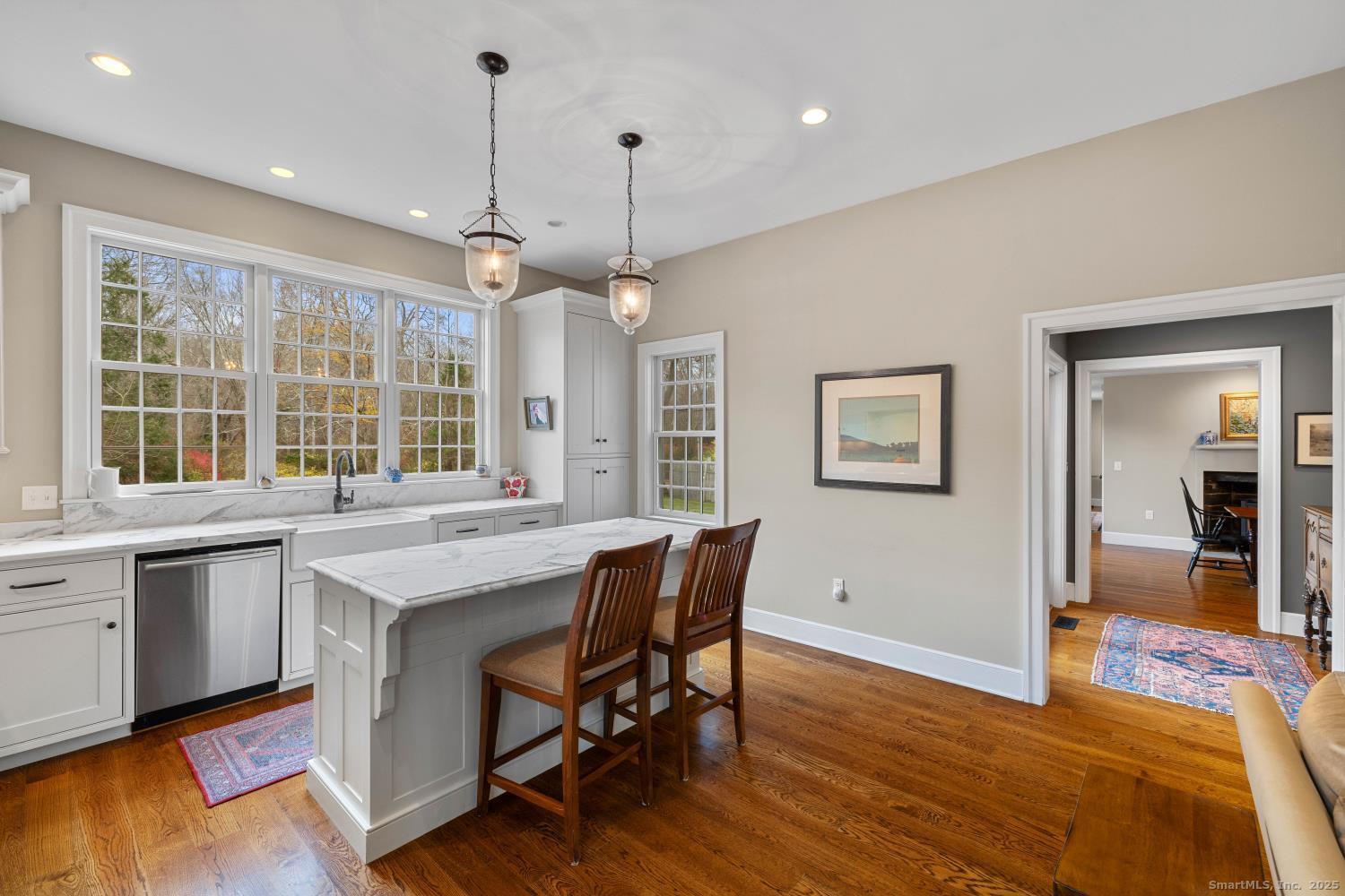 138 School House Road Old Saybrook, CT 06475 - Photo 22 of 40 a open kitchen with stainless steel appliances granite countertop a stove a refrigerator a sink dishwasher with a dining table and chairs with wooden floor