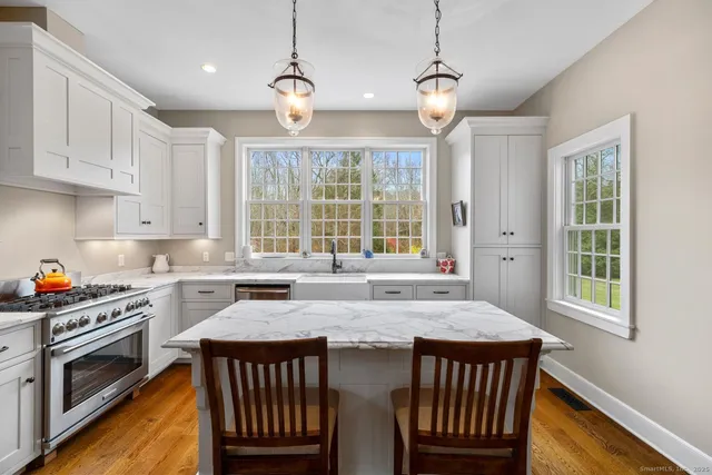 a kitchen with granite countertop a stove a sink a dining table and chairs
