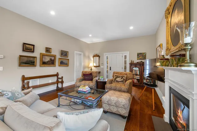 a living room with furniture a flat screen tv and a fireplace