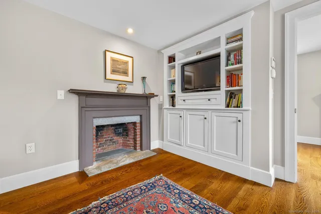 a living room with a fireplace and flat screen tv