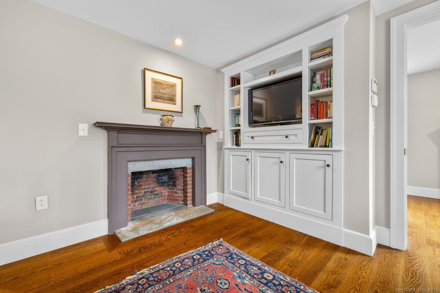 138 School House Road Old Saybrook, CT 06475 - Photo 36 of 40 a living room with a fireplace and flat screen tv