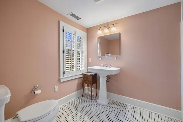 a bathroom with a sink a toilet and a mirror