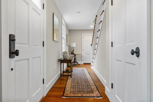 a view of a hallway with wooden floor and staircase