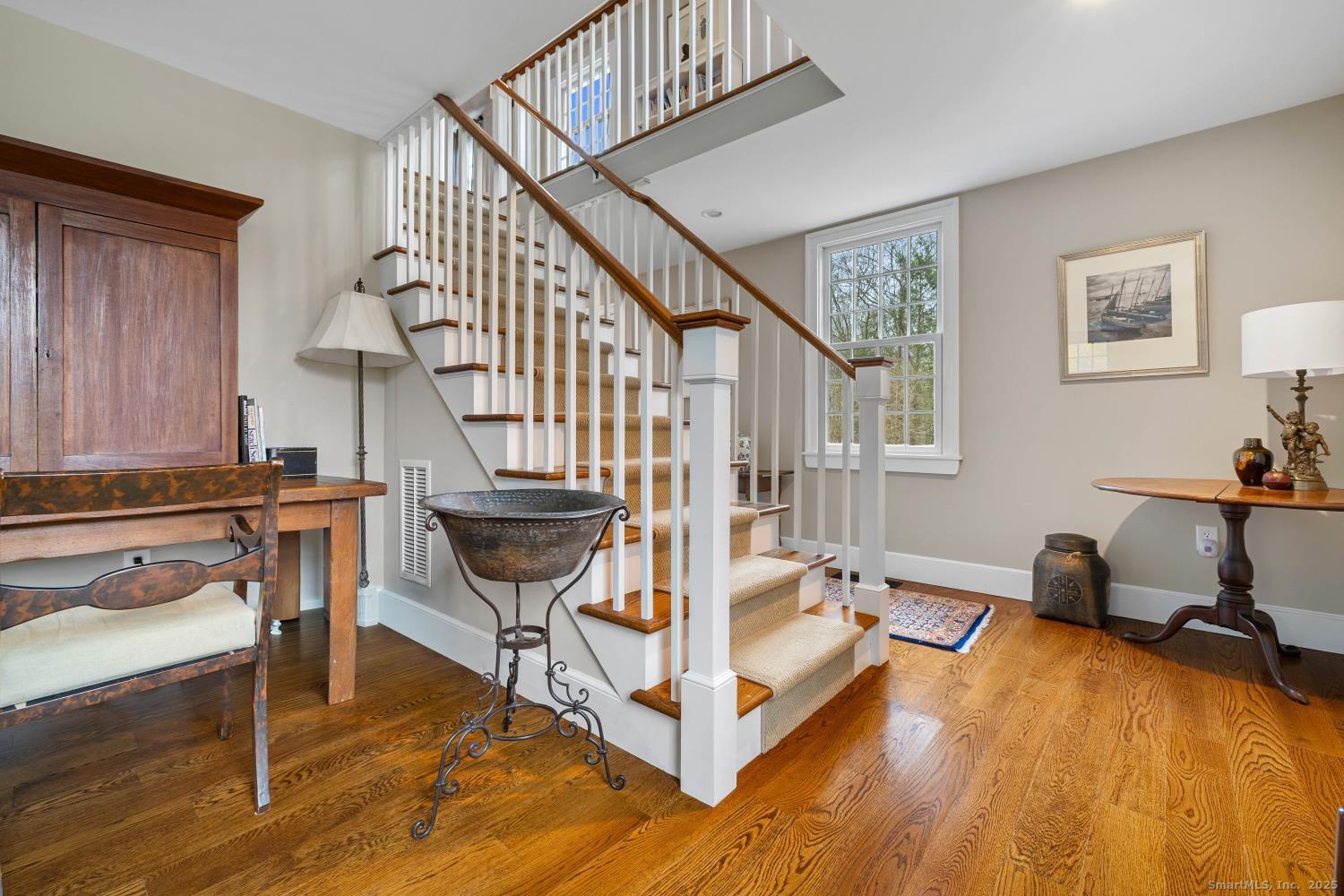 138 School House Road Old Saybrook, CT 06475 - Photo 6 of 40 a view of a livingroom with furniture a fireplace wooden floor and windows