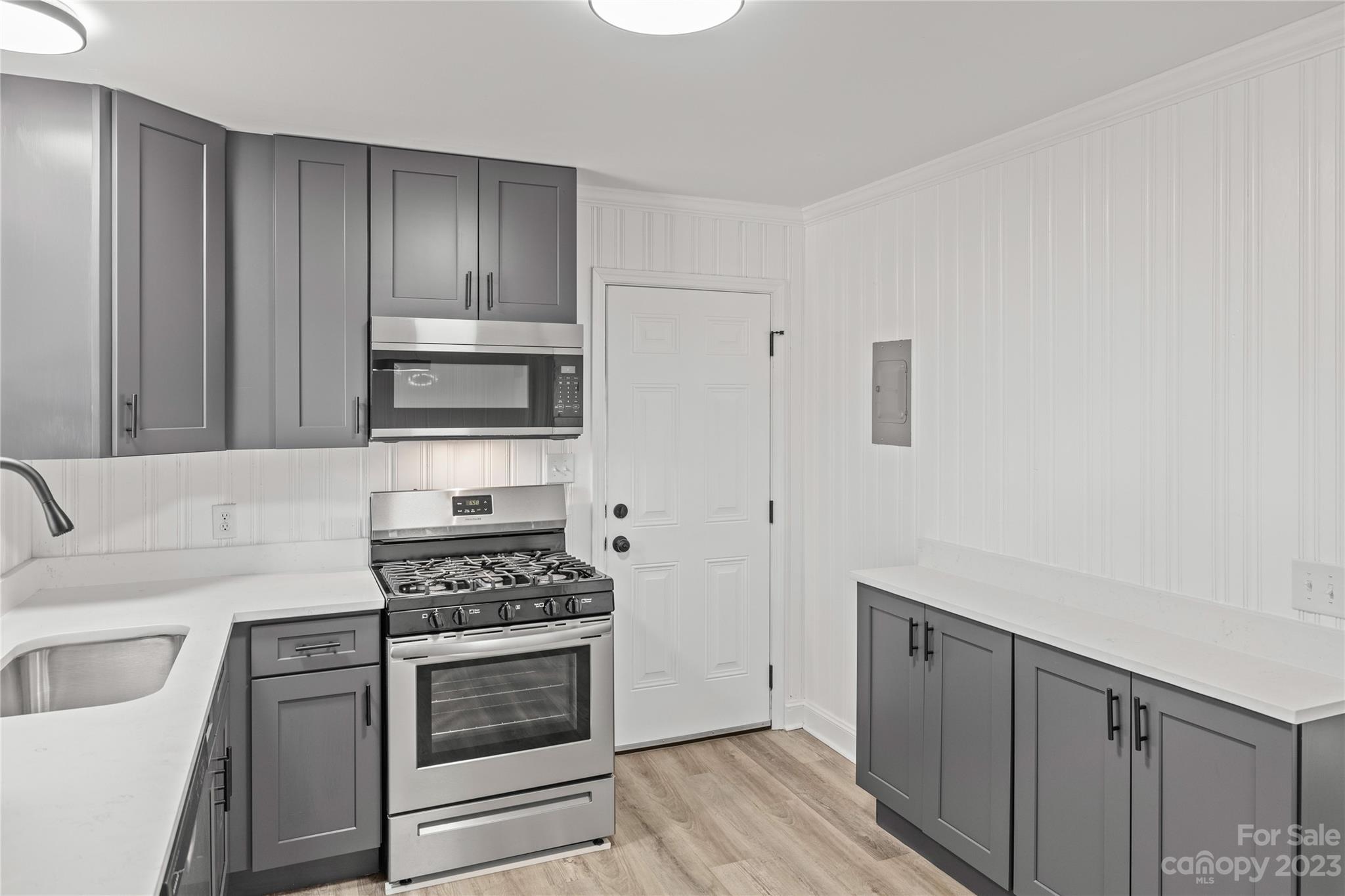 a kitchen with cabinets appliances and a wooden floor