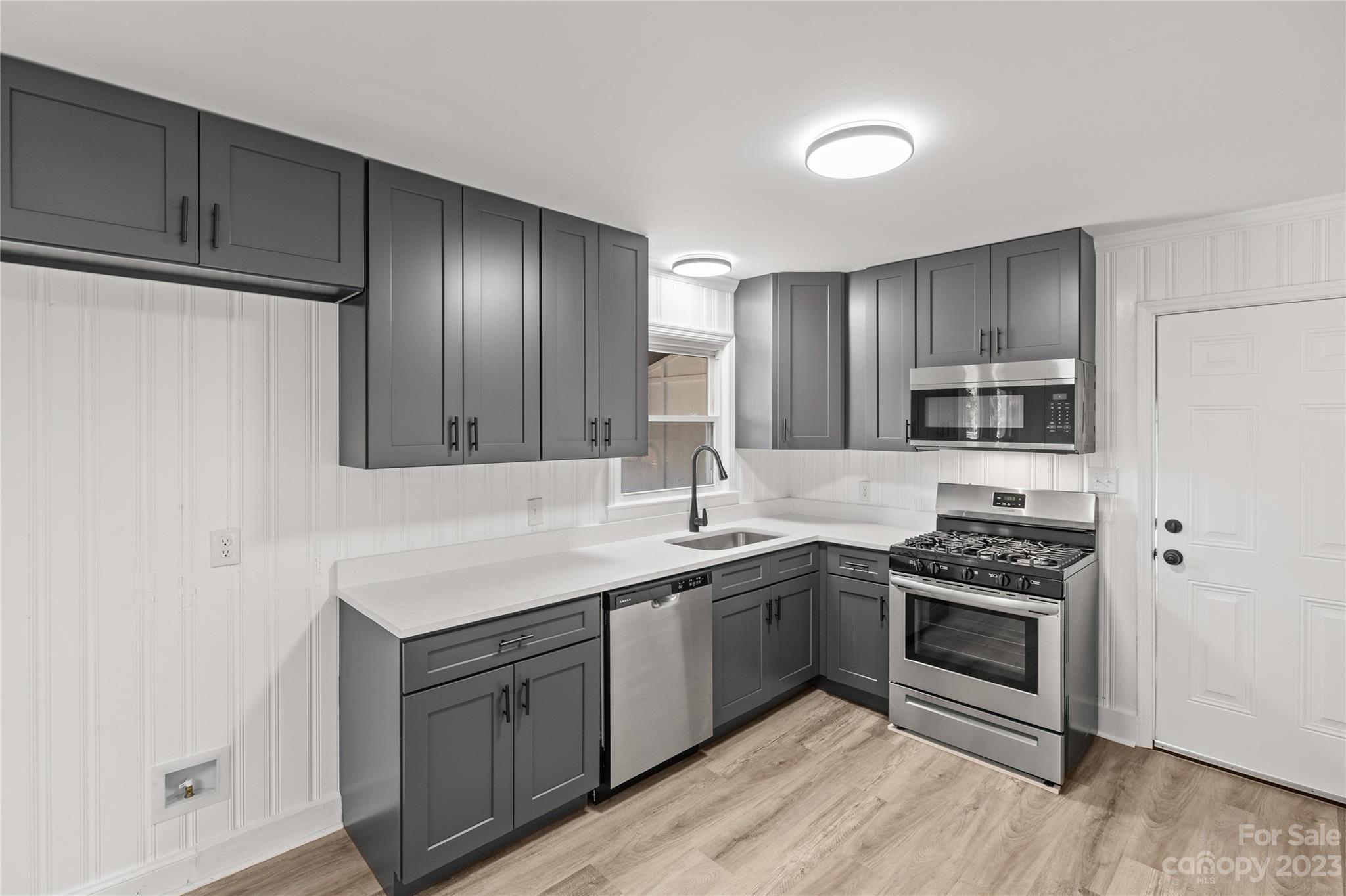 1415 East Main Street Cherryville, NC 28021 - Photo 4 of 34 a kitchen with stainless steel appliances granite countertop a stove a sink and a refrigerator