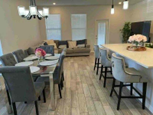 a kitchen with stainless steel appliances granite countertop a sink a stove a refrigerator and island with wooden floor