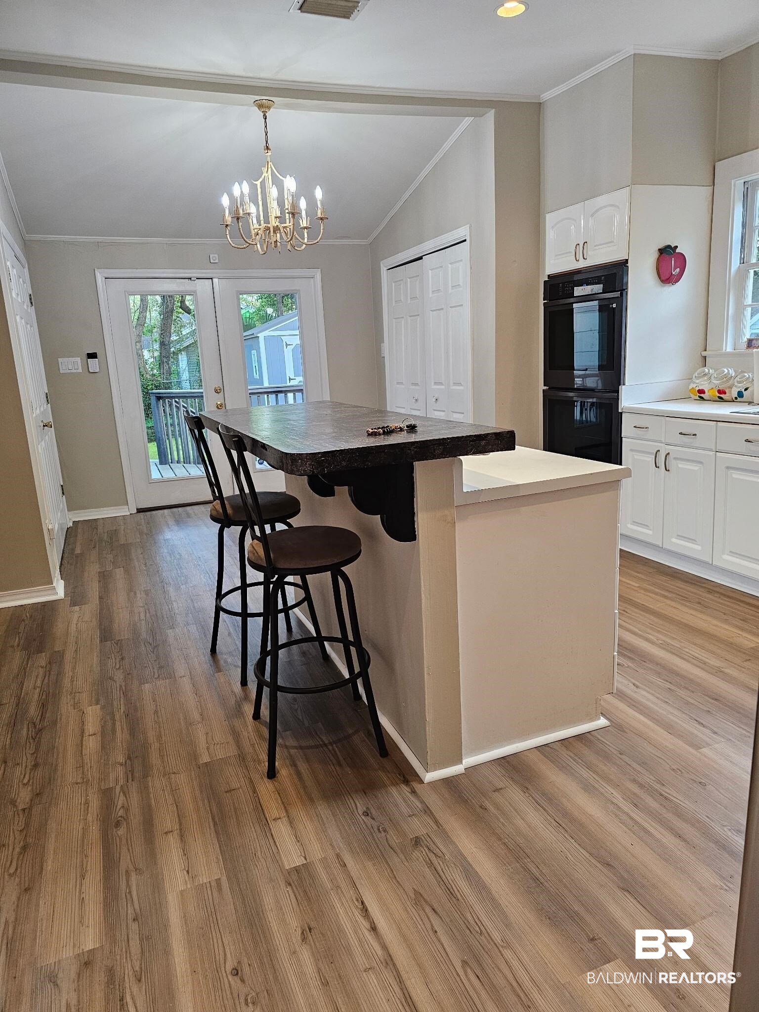 1215 Church Street Mobile, AL 36604 - Photo 4 of 23 Kitchen featuring crown molding, white cabinetry, dobule oven black, and a kitchen breakfast bar