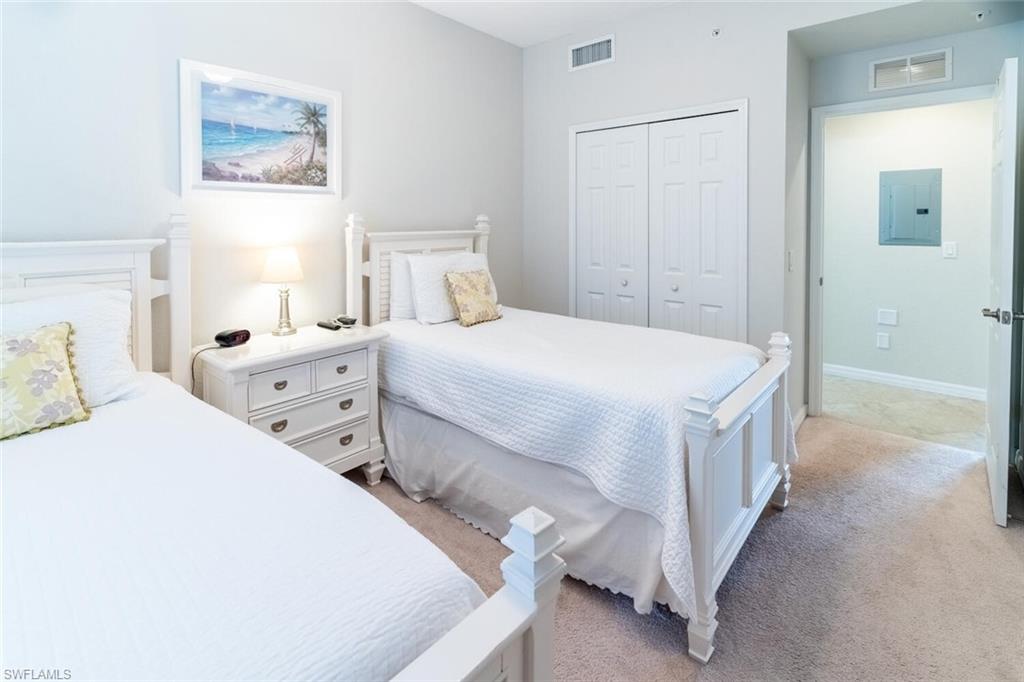 9731 Acqua Court, Unit 536 Naples, FL 34113 - Photo 21 of 47 a bedroom with a bed and a lamp on dresser