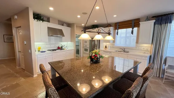 a kitchen with stainless steel appliances dining table and chairs