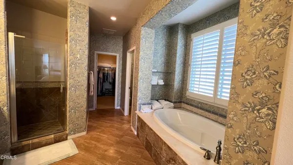 a bathroom with a granite countertop tub shower and mirror