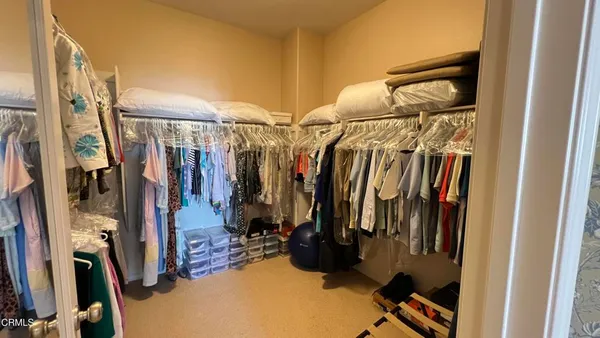 a view of walk in closet with clothes and shoes