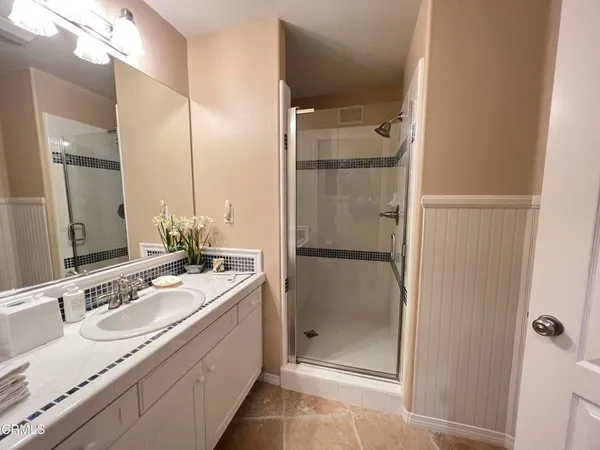 a bathroom with a double vanity sink mirror and shower