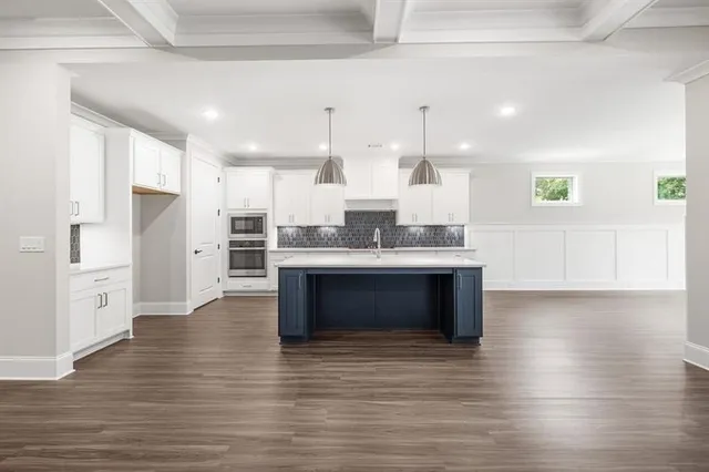 a kitchen with white cabinets sink and window