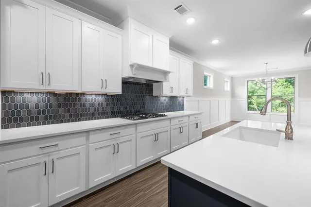 an empty room with wooden floor windows and exposed bricks