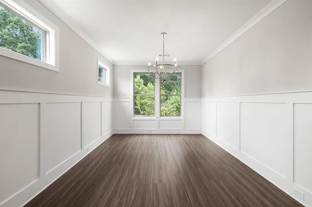 a kitchen with a sink a counter top space stainless steel appliances and a chandelier