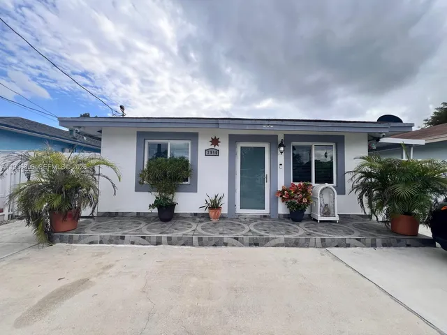 a view of a house with potted plants and a large window