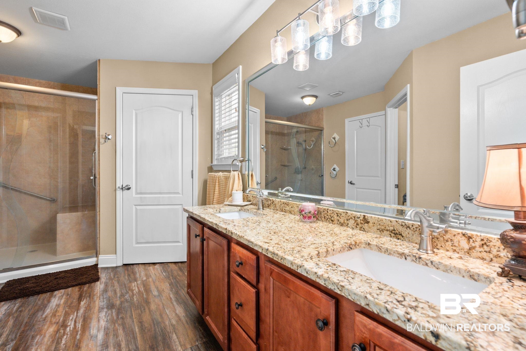 562 Vestige Mews Foley, AL 36535 - Photo 28 of 54 Double vanity with a speckled countertop, undermount sinks, and dark wood cabinetry