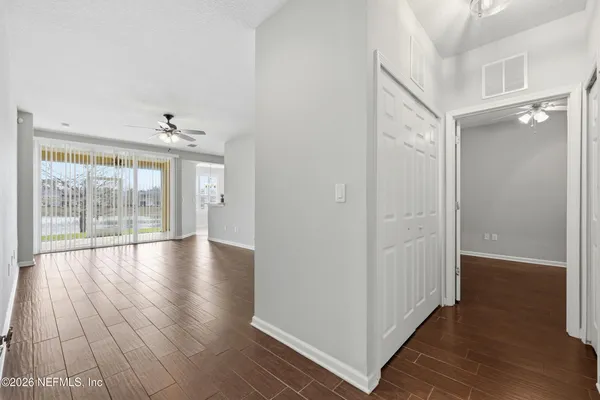 a view of an empty room with wooden floor and a window