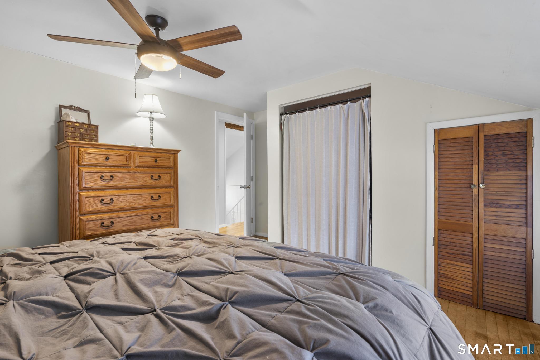 89 Green Meadow Road Milford, CT 06461 - Photo 15 of 31 a bedroom with a bed and a chandelier