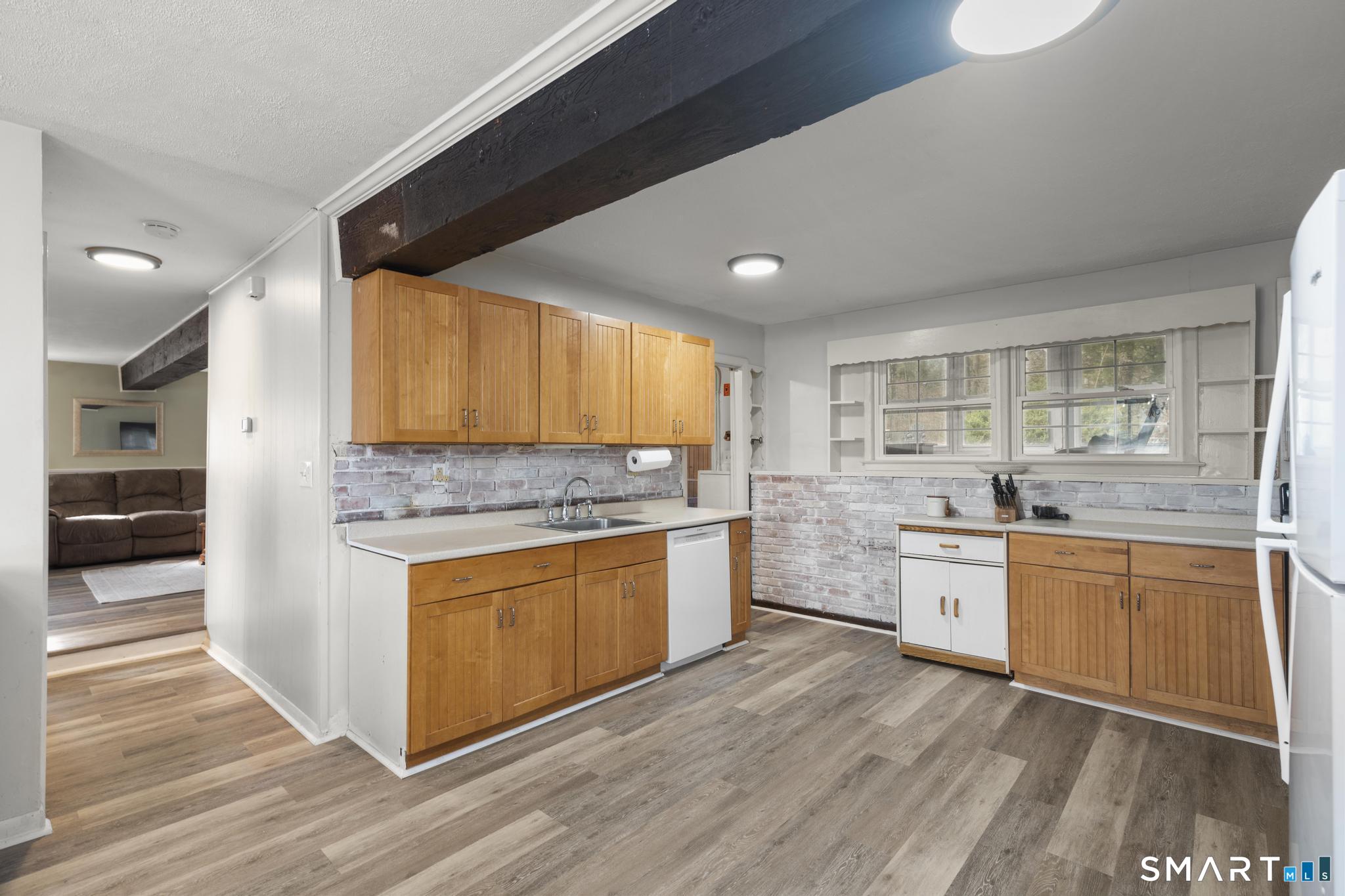 89 Green Meadow Road Milford, CT 06461 - Photo 4 of 31 a large kitchen with granite countertop a stove top oven a sink and dishwasher with wooden floor