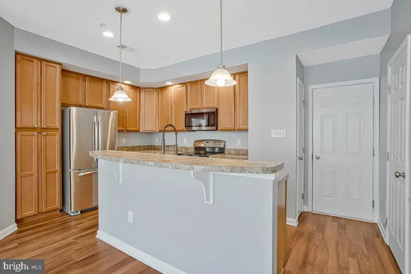 a kitchen with stainless steel appliances granite countertop a sink a stove and a refrigerator