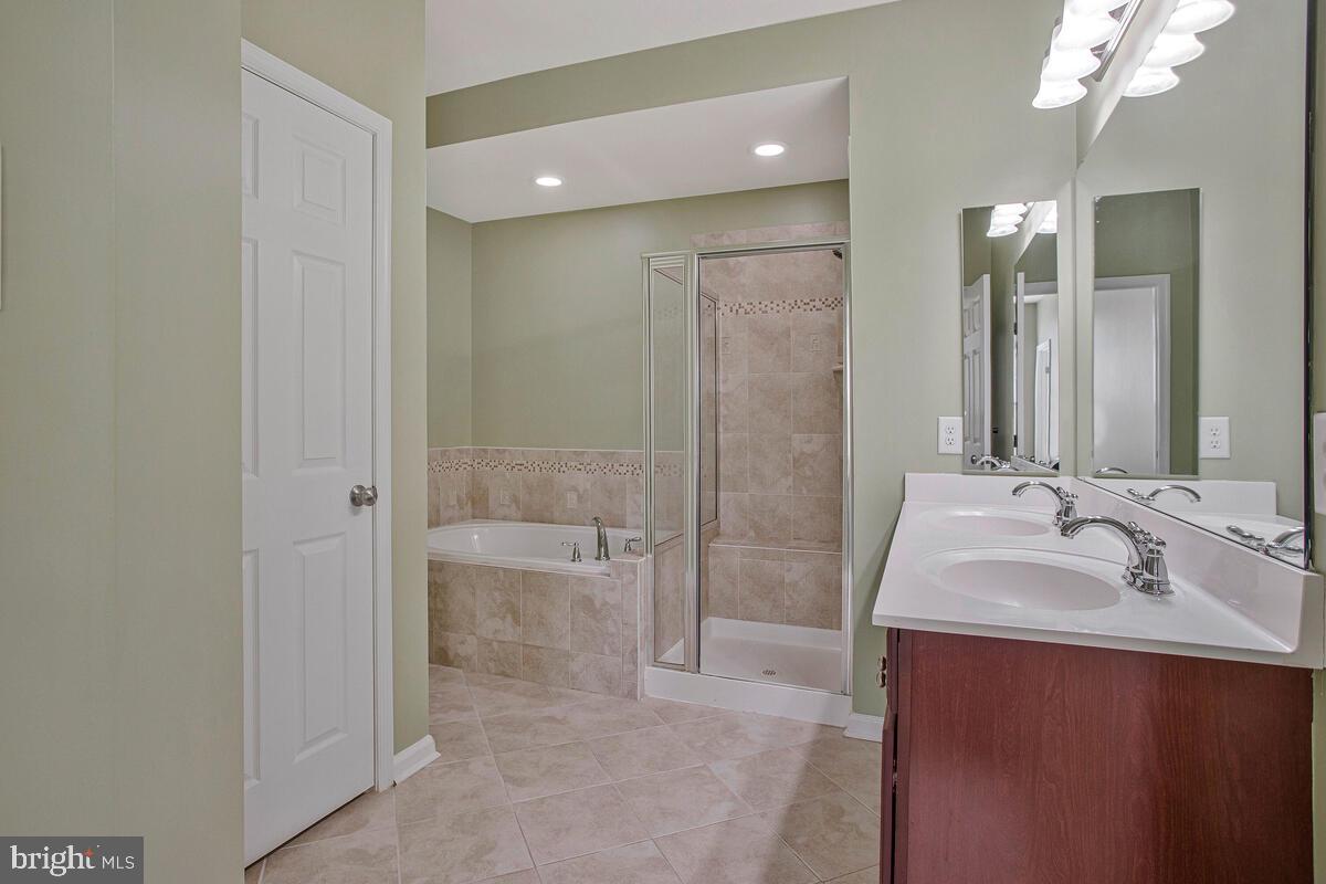 8049 Forest Ridge Drive, Unit 3 Chesapeake Beach, MD 20732 - Photo 24 of 40 a bathroom with a sink a toilet and shower