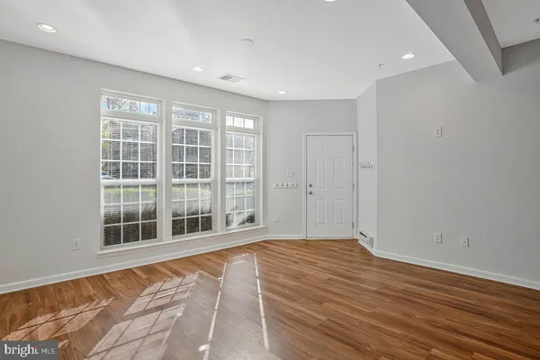 a kitchen with stainless steel appliances granite countertop a refrigerator a sink dishwasher and a stove with wooden floor