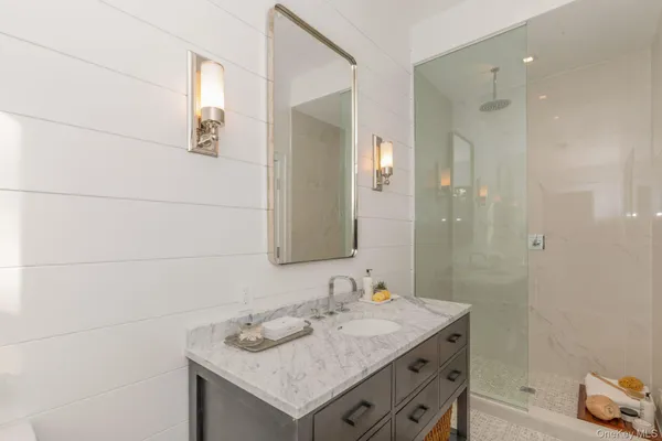 a bathroom with a granite countertop sink and a mirror