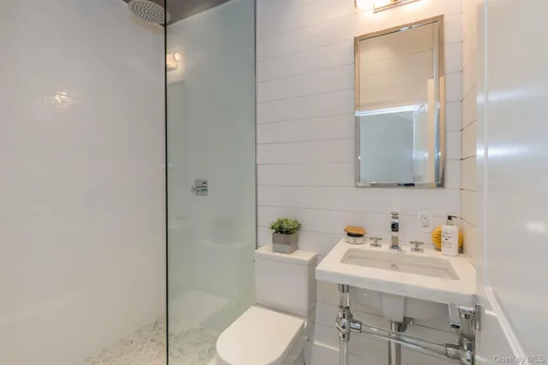a bathroom with a sink vanity mirror and toilet