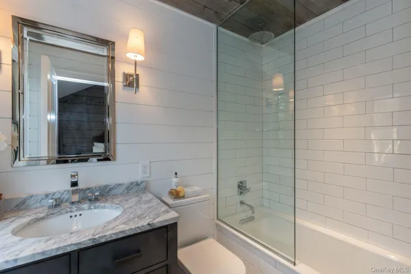 a bathroom with a granite countertop sink toilet and shower