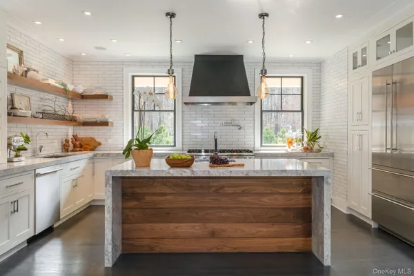 a kitchen with kitchen island granite countertop a stove a sink and a refrigerator