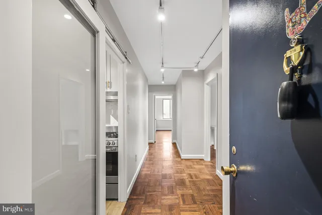 a view of a hallway with wooden floor and staircase