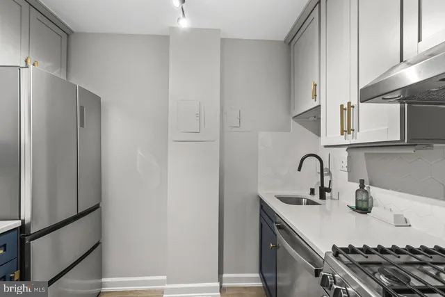 a kitchen with stainless steel appliances a sink and cabinets